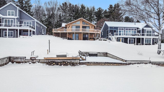 snow covered house featuring a deck