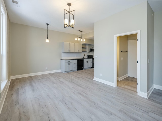 kitchen with pendant lighting, sink, light hardwood / wood-style floors, and black appliances