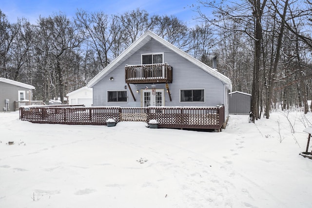 snow covered property with a deck and an outdoor structure