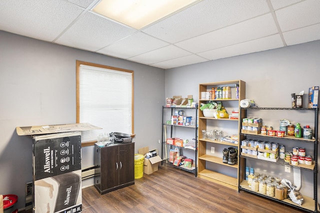 home office featuring dark wood-type flooring, a paneled ceiling, and baseboard heating