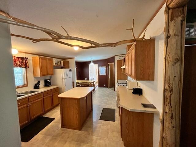 kitchen with sink, a center island, and white refrigerator