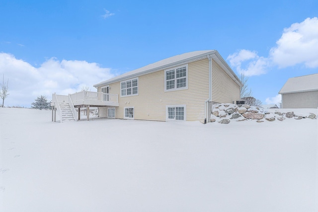 snow covered property with a wooden deck