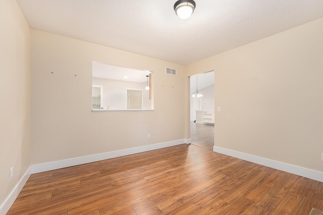 spare room with lofted ceiling and hardwood / wood-style floors