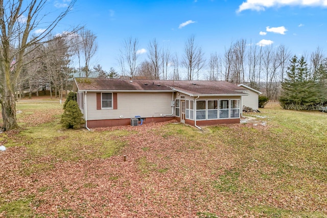 back of property featuring a lawn and a sunroom