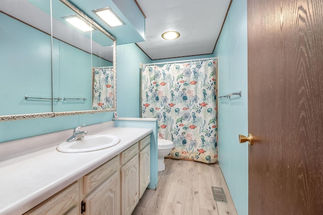 bathroom featuring wood-type flooring, a shower with shower curtain, vanity, and toilet