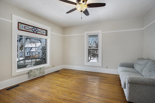 living area with hardwood / wood-style flooring and ceiling fan