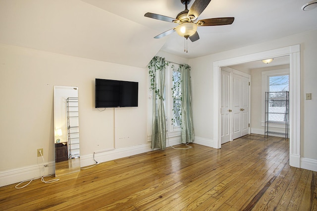 unfurnished living room featuring ceiling fan, vaulted ceiling, and wood-type flooring