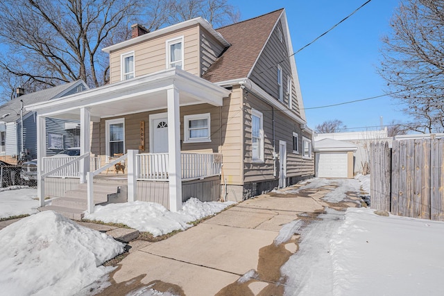 view of front of home featuring a garage, an outdoor structure, and a porch