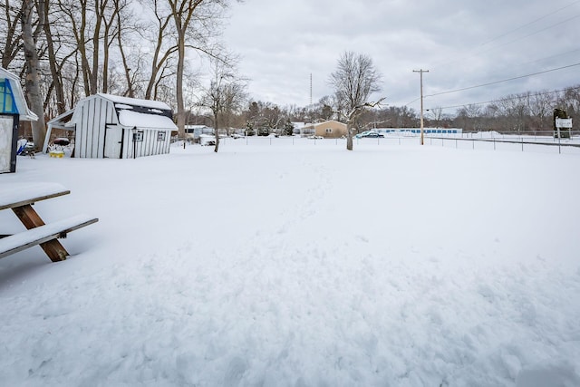 yard layered in snow with a shed