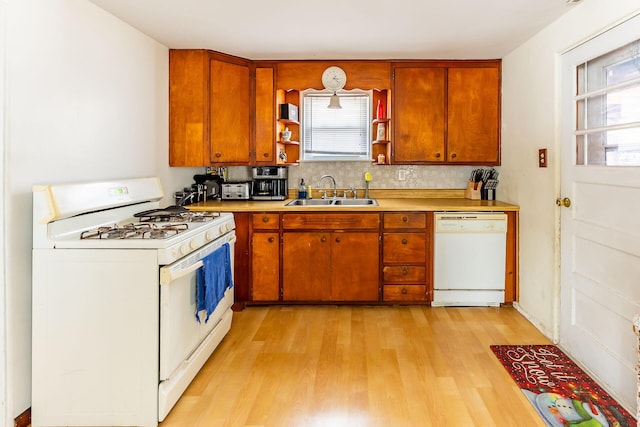 kitchen featuring sink, white appliances, and light hardwood / wood-style flooring