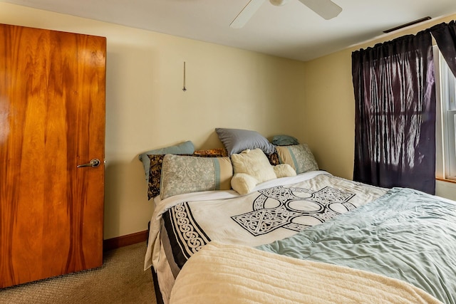 bedroom with ceiling fan and dark carpet