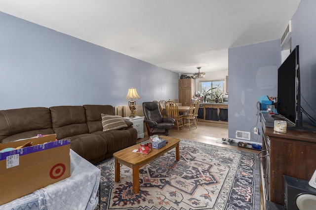 living room with hardwood / wood-style floors and a notable chandelier