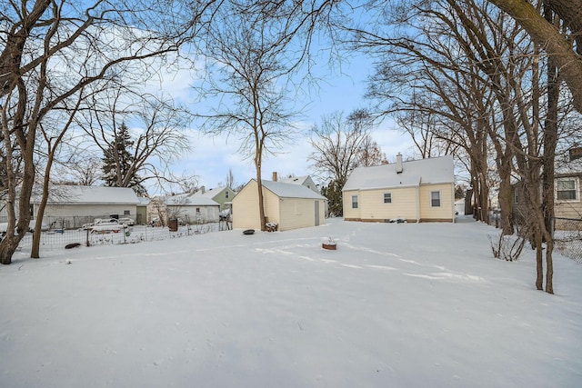 snowy yard featuring an outbuilding