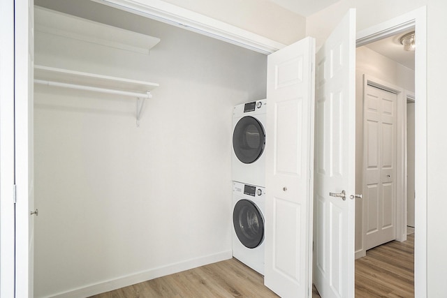 clothes washing area featuring light hardwood / wood-style floors and stacked washer and dryer