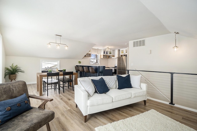 living room with light hardwood / wood-style floors and lofted ceiling