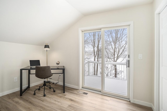 home office with light hardwood / wood-style flooring and lofted ceiling