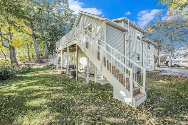 view of side of home featuring a wooden deck and a lawn