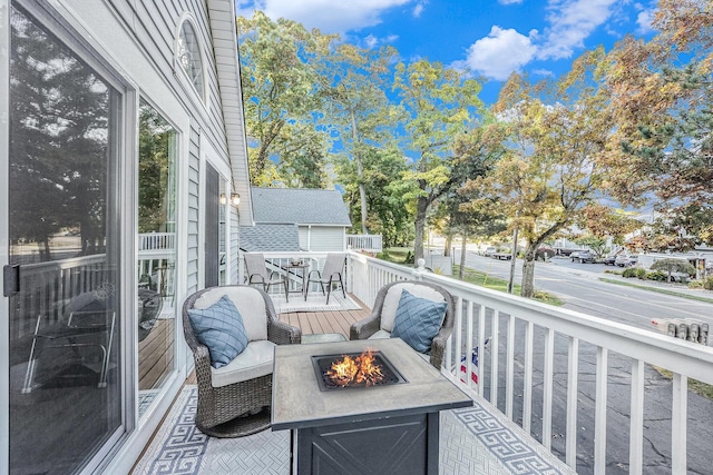 wooden balcony with a deck and an outdoor fire pit