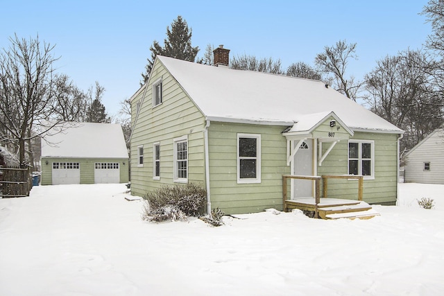 view of front of home with a garage and an outbuilding