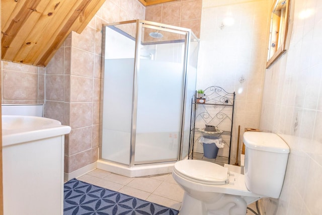 bathroom with tile walls, tile patterned flooring, a shower with shower door, and toilet