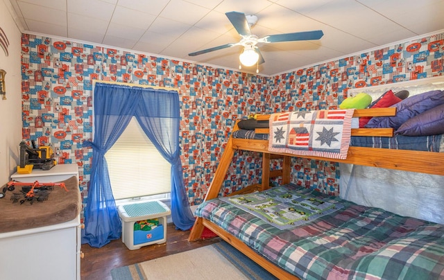 bedroom featuring dark wood-type flooring, ceiling fan, and ornamental molding