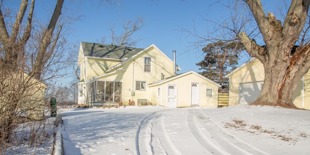 view of front of home featuring a garage and a sunroom