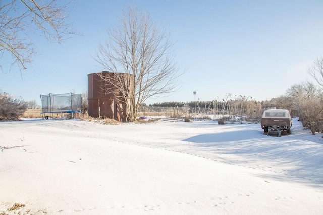 yard covered in snow featuring a trampoline