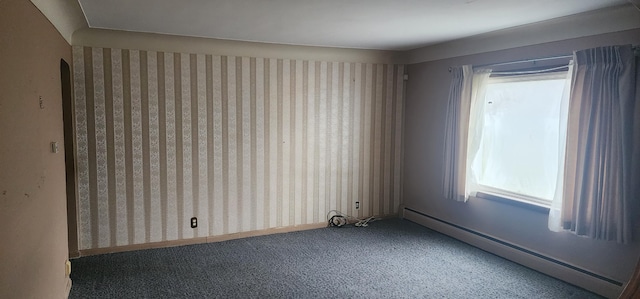 carpeted spare room featuring a baseboard heating unit