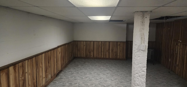 basement featuring light carpet and a paneled ceiling