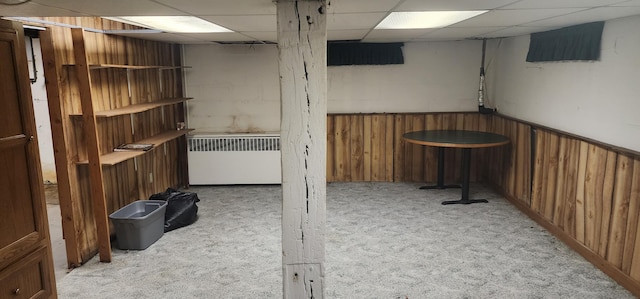 basement featuring light colored carpet and a drop ceiling