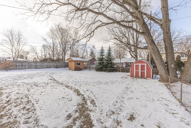 snowy yard with a storage shed