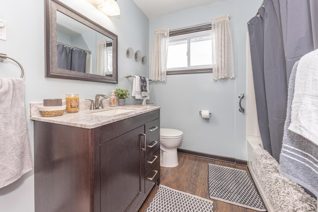 full bathroom featuring toilet, shower / bath combination with curtain, hardwood / wood-style flooring, and vanity