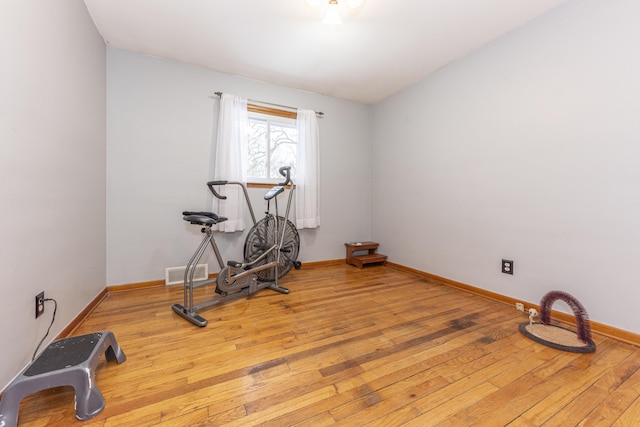 exercise room with light hardwood / wood-style floors