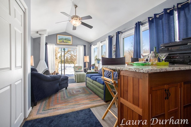 living room with wood-type flooring, ceiling fan, and vaulted ceiling