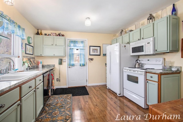 kitchen featuring hardwood / wood-style flooring, white appliances, sink, and green cabinetry