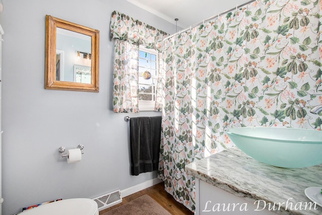 bathroom with hardwood / wood-style flooring, vanity, and toilet