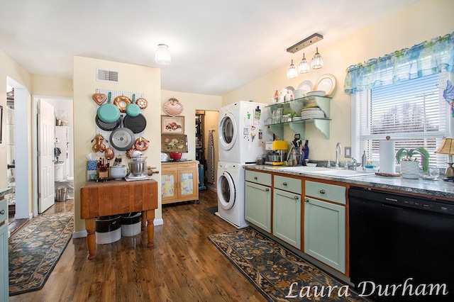 interior space with pendant lighting, stacked washer and dryer, sink, black dishwasher, and dark hardwood / wood-style flooring