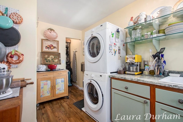 laundry room with stacked washer and dryer and dark wood-type flooring