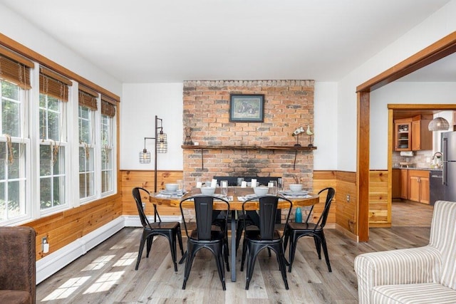 dining space with a baseboard radiator and light wood-type flooring