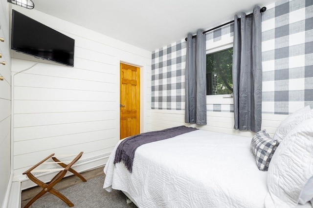 bedroom featuring wood walls