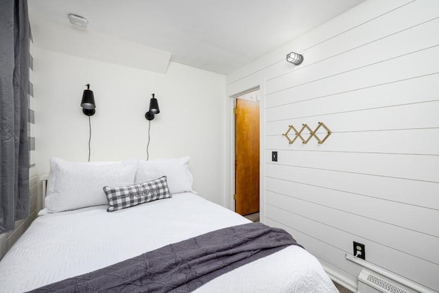 bedroom featuring wood walls