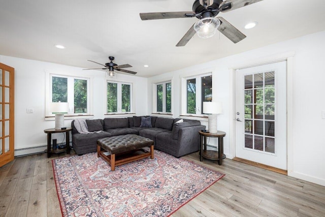 living room featuring ceiling fan, light hardwood / wood-style flooring, and a baseboard radiator