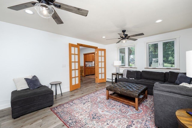 living room featuring ceiling fan, french doors, and light hardwood / wood-style floors