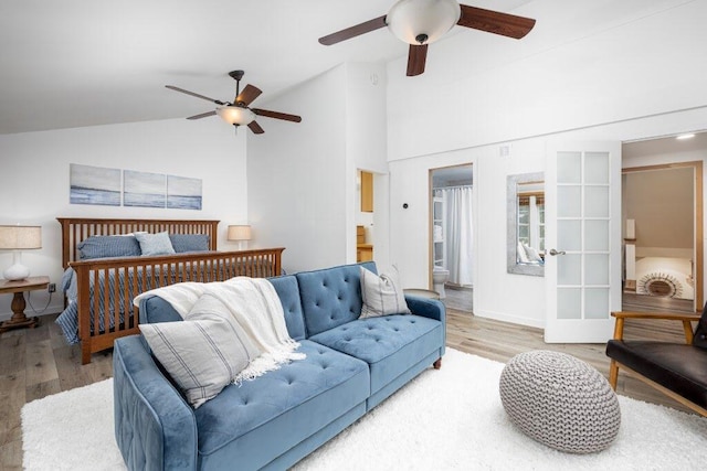 bedroom featuring lofted ceiling, connected bathroom, french doors, light wood-type flooring, and ceiling fan