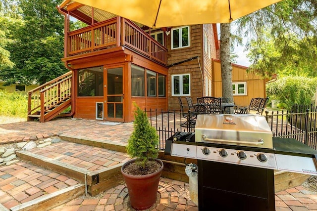 view of patio / terrace featuring a balcony, a sunroom, and grilling area