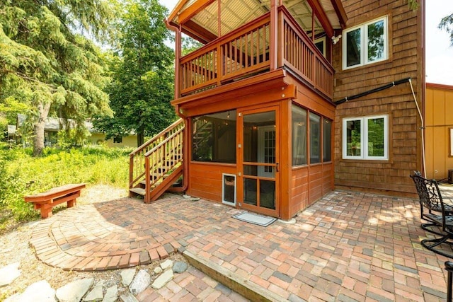 view of patio with a balcony and a sunroom