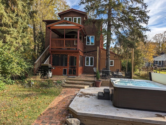 back of property with a patio area and a hot tub