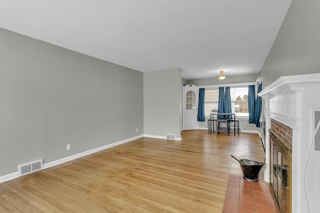 unfurnished living room featuring wood-type flooring and a fireplace