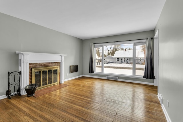 unfurnished living room with a fireplace and hardwood / wood-style floors