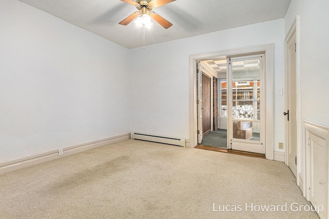 carpeted spare room with a baseboard heating unit and ceiling fan
